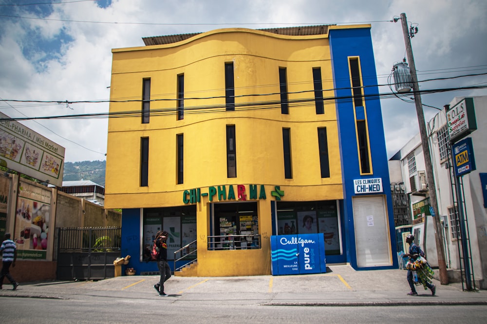 a yellow and blue building on a street corner