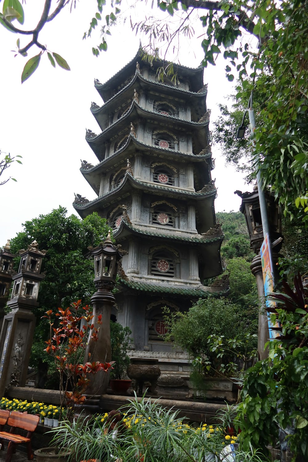 a tall tower sitting next to a lush green forest