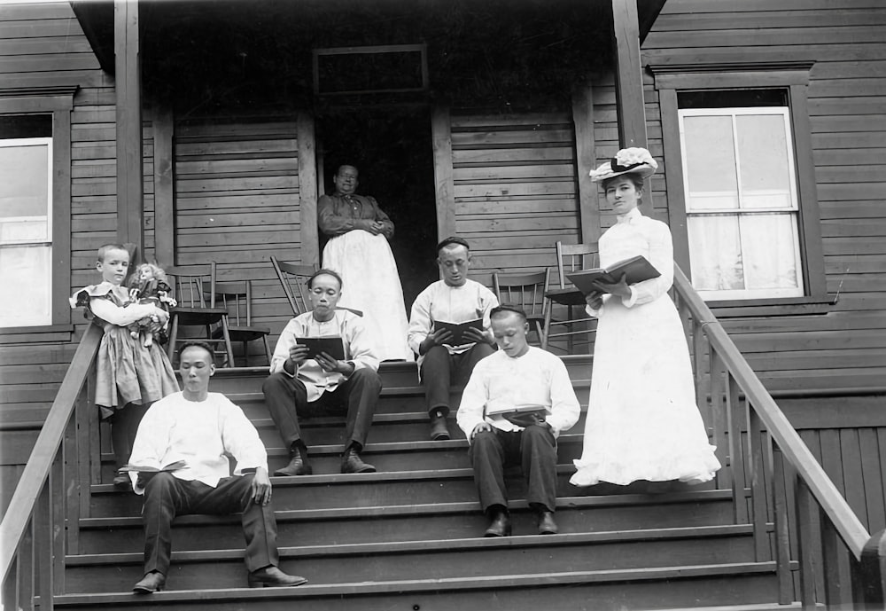 a group of people sitting on the steps of a house