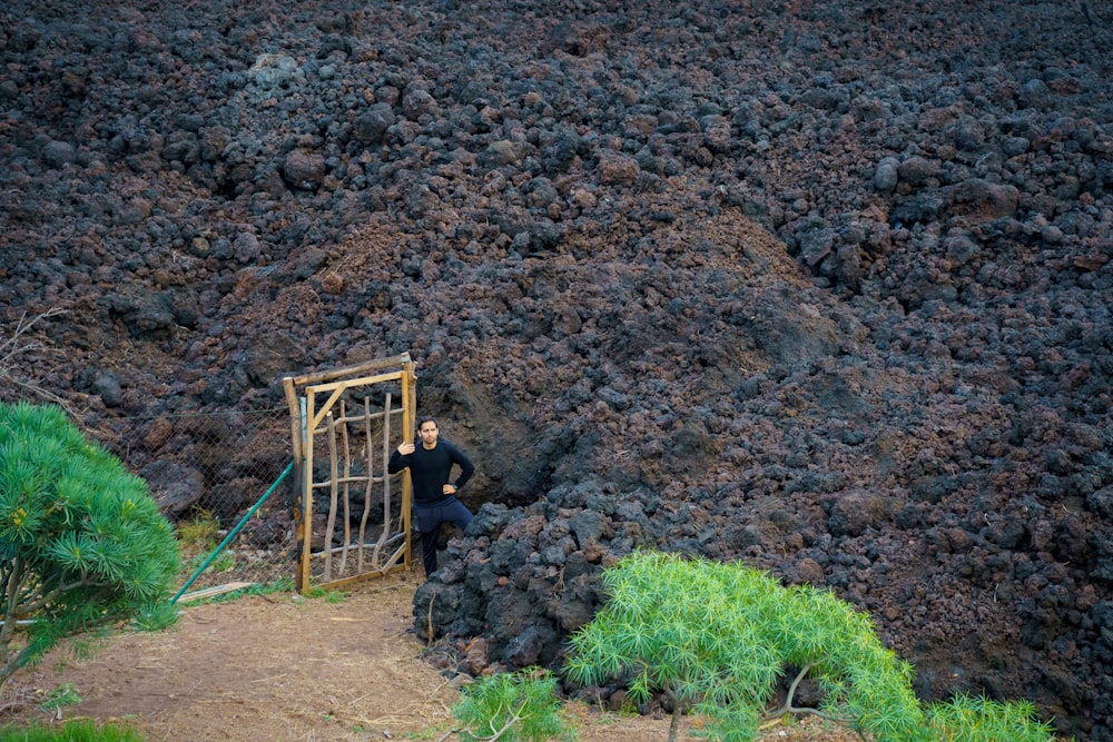 um homem em pé na frente de um portão no topo de uma montanha