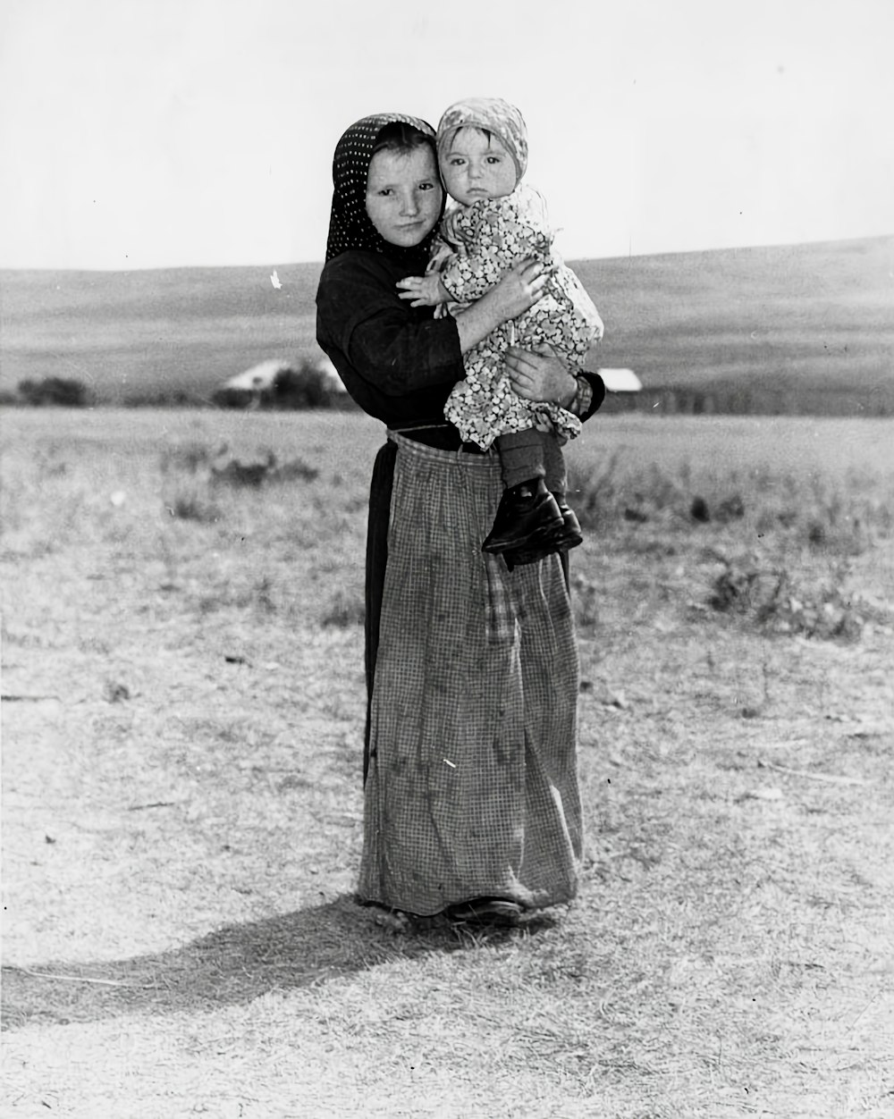 a black and white photo of a woman holding a child