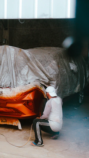 Close-up of a skilled technician carefully repairing a car dent caused by hail damage.
