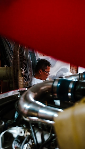 Photo of skilled technicians assembling a large centrifugal exhaust fan in a bright industrial workshop.
