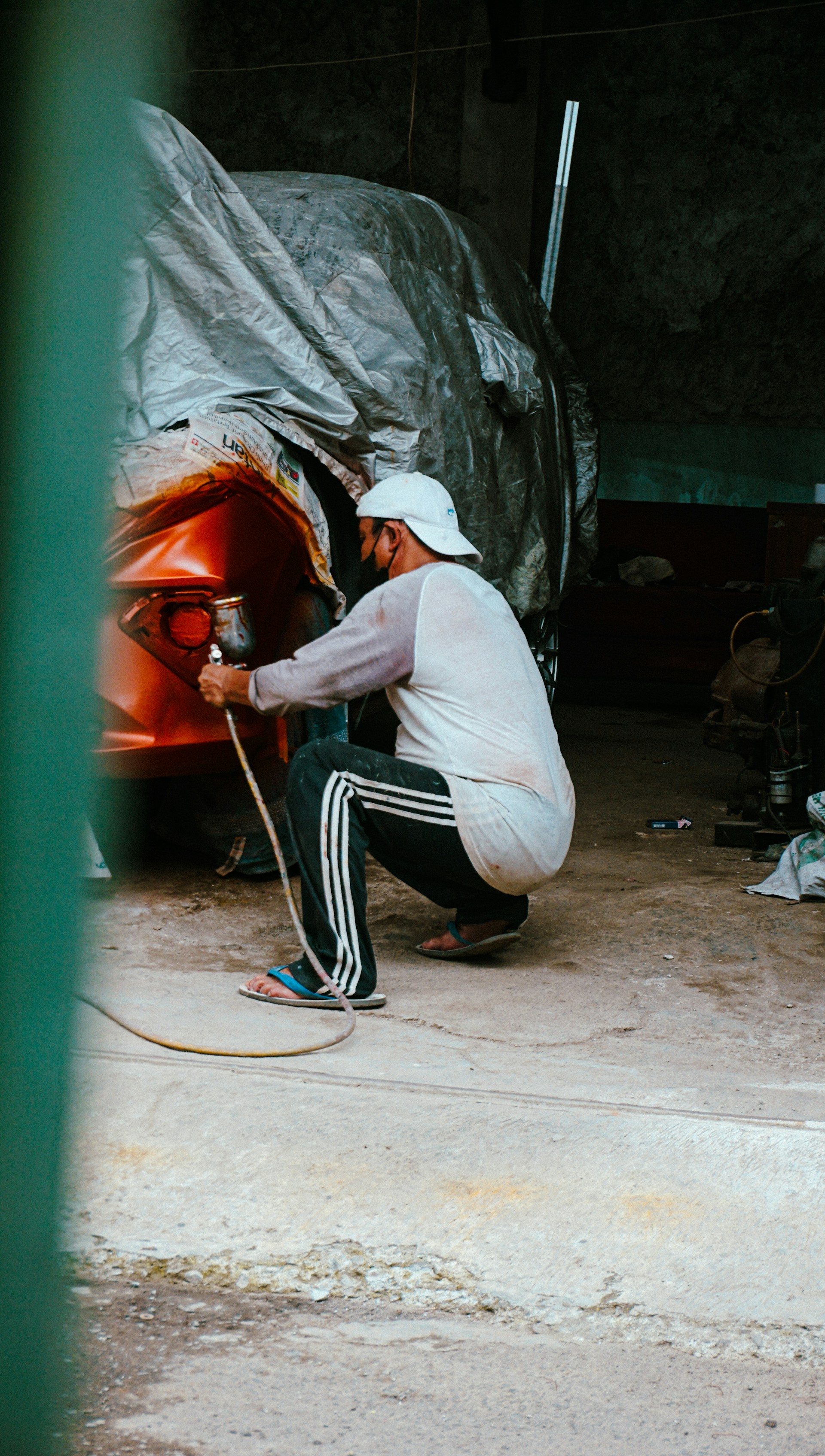 a man kneeling down with a hose in his hand