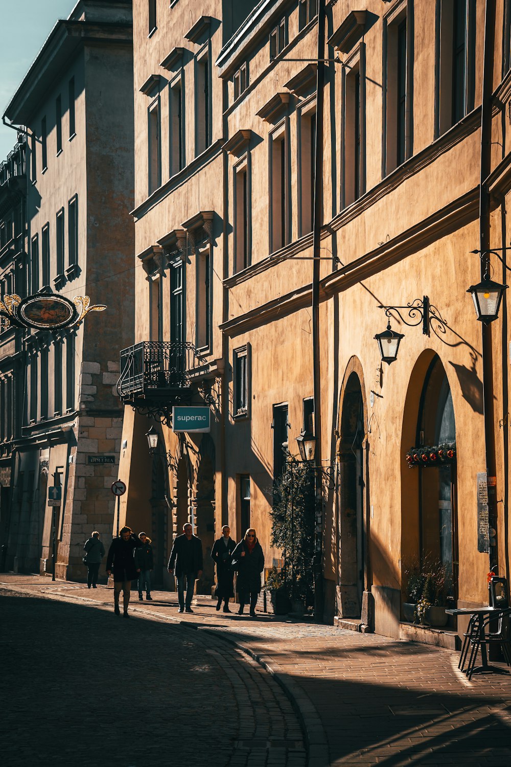 a group of people walking down a street next to tall buildings