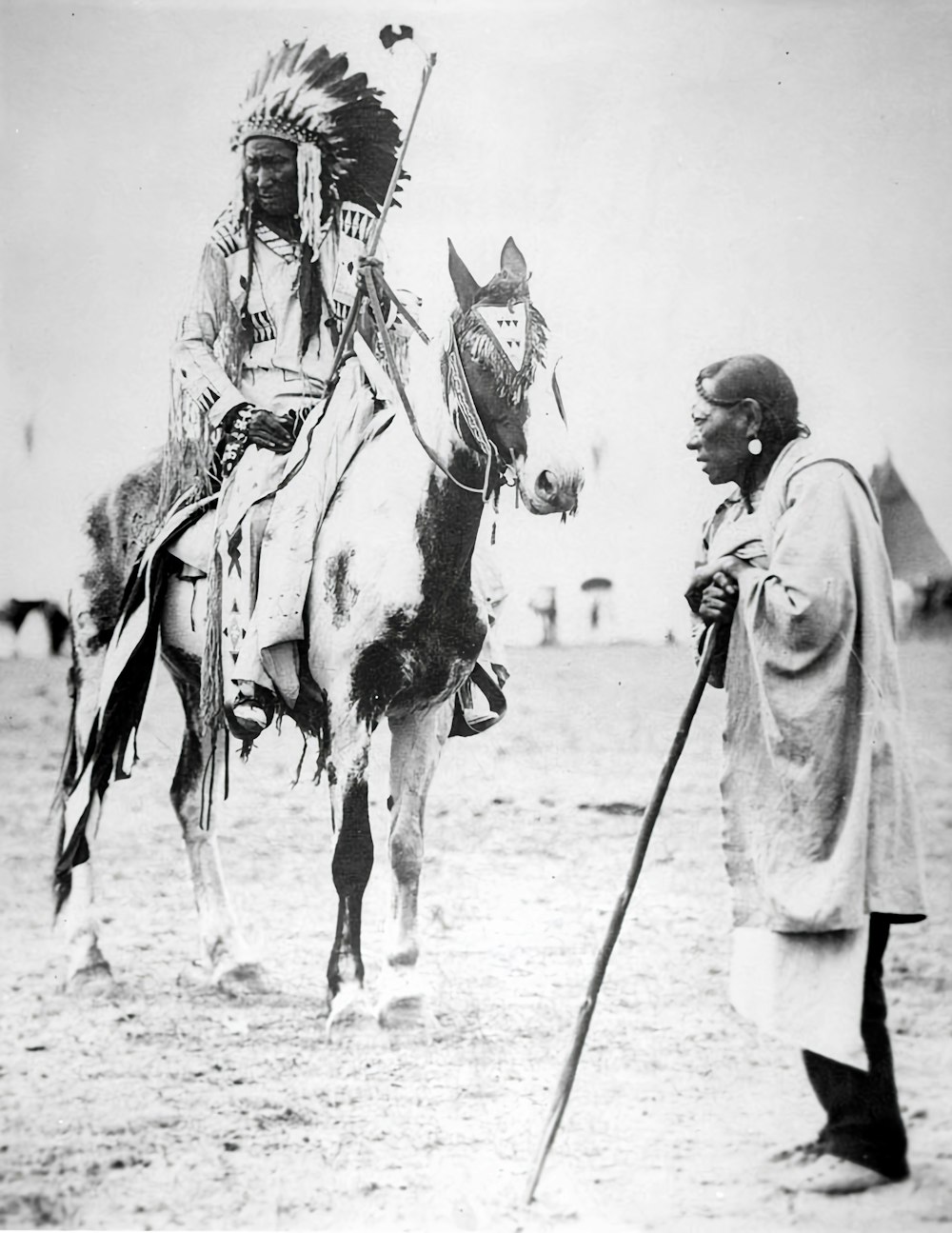 a man standing next to a man on a horse