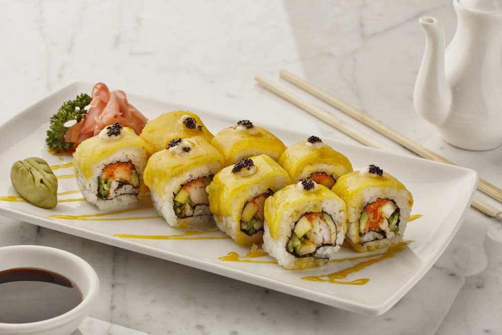 a white plate topped with sushi next to a cup of coffee