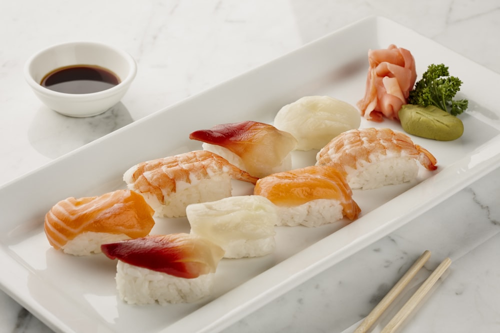 a white plate topped with sushi and chopsticks