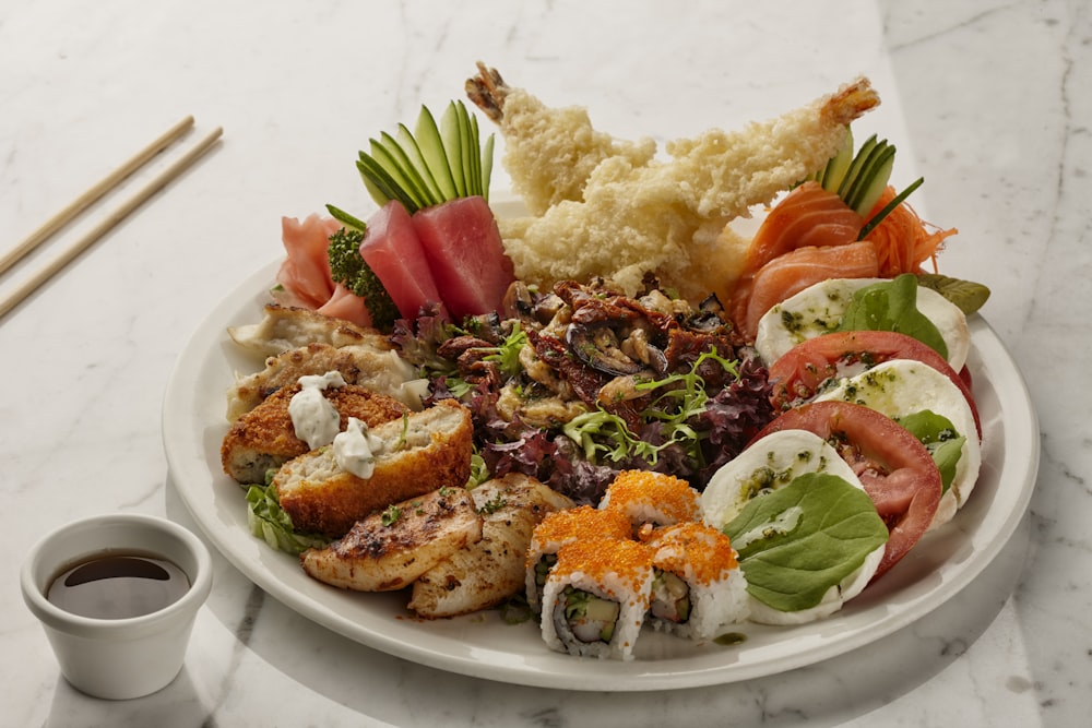 Un plato blanco cubierto con muchos tipos diferentes de comida