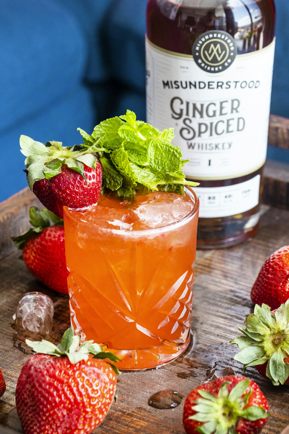 a wooden tray topped with a drink and strawberries