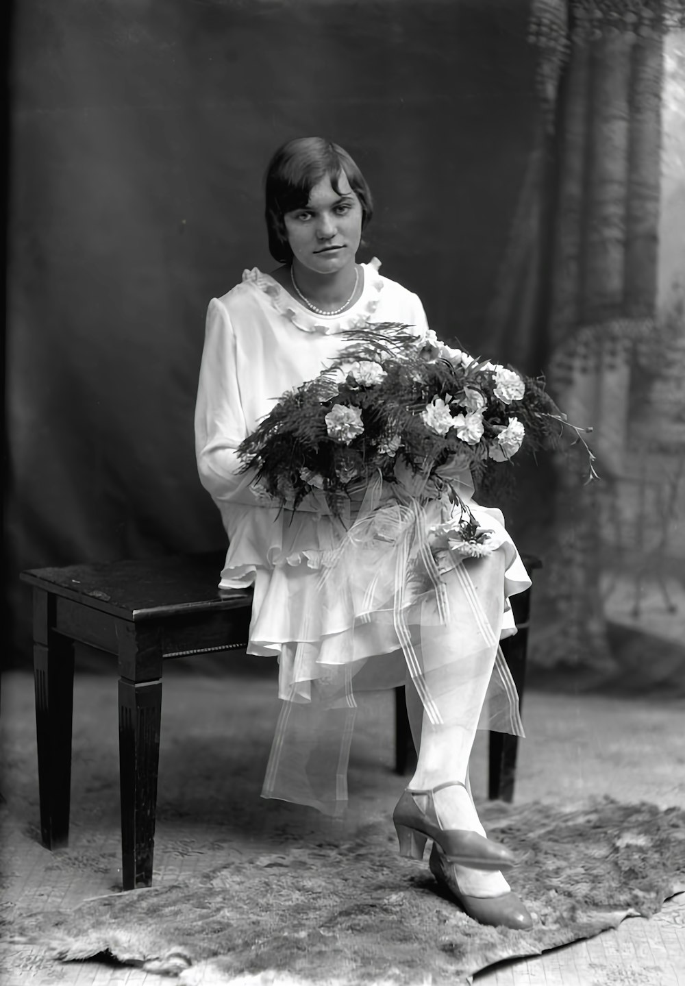 a woman sitting on a bench holding a bouquet of flowers