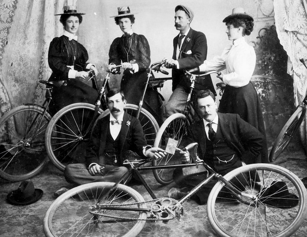 a black and white photo of a group of people with bicycles