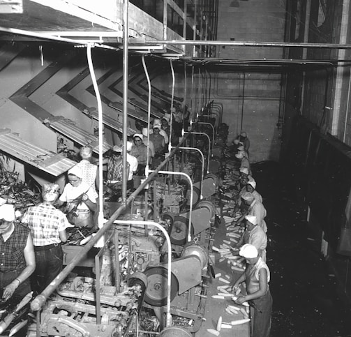 a black and white photo of men working in a factory
