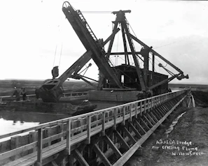 Maintenance dredging operation with heavy machinery clearing the riverbed near the docks