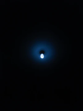 Minimalist air purification device emitting a soft blue light in a bright, airy room.