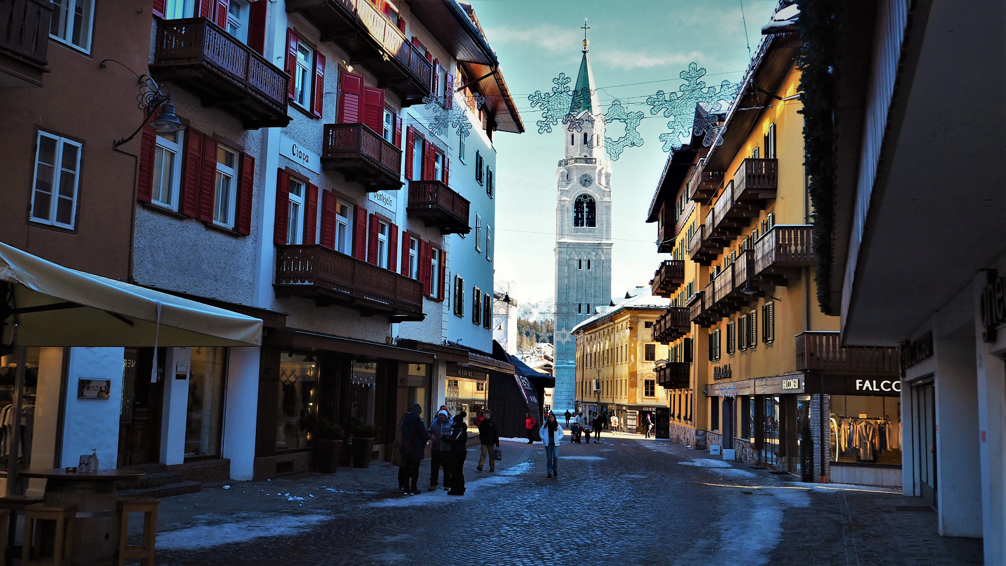 People walking down Cortina d'Ampezzo's cobbled main street