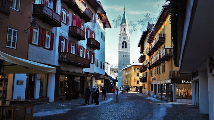 Corso Italia, Cortina's pedestrian main street, lined with painted buildings and the town's tall bell tower in winter light