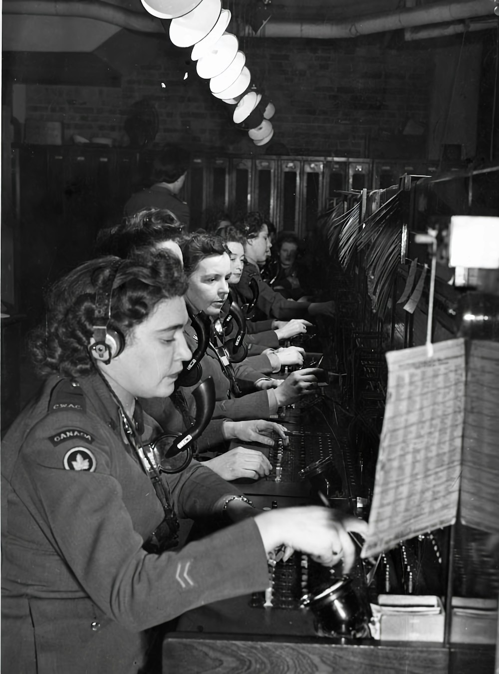 a group of women sitting at a table working on a machine