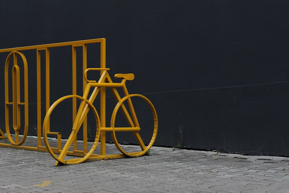 a yellow bike parked next to a yellow gate