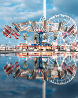 A vibrant amusement park scene with colorful rides spinning under a bright blue sky.