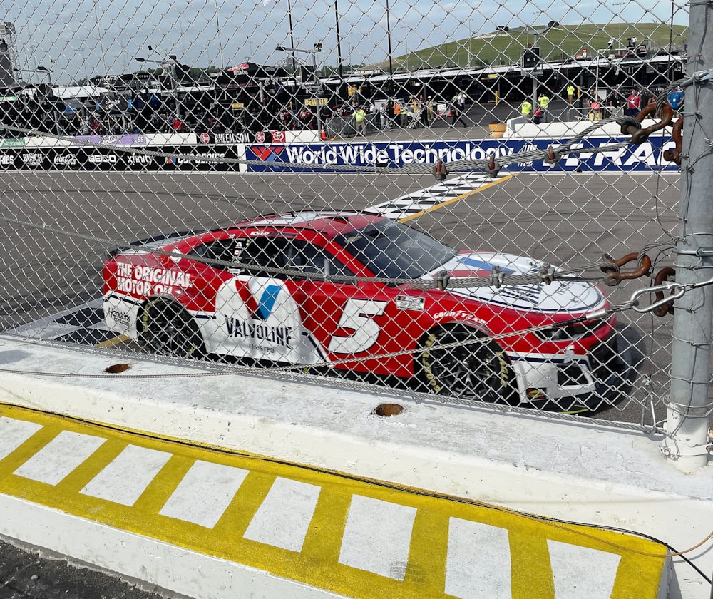 a red race car sitting on top of a race track