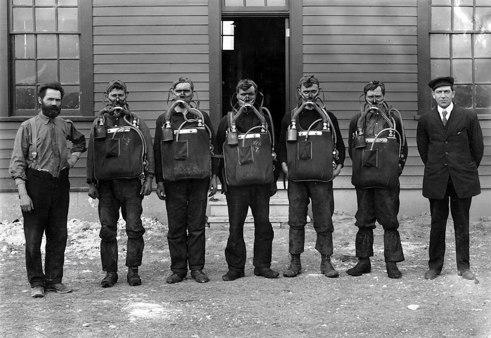 a group of men standing next to each other in front of a building