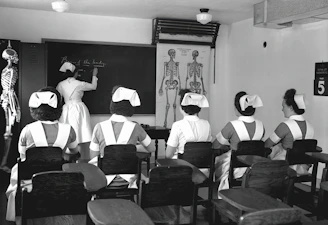 A nurse reviewing a detailed study schedule spread out on a desk.