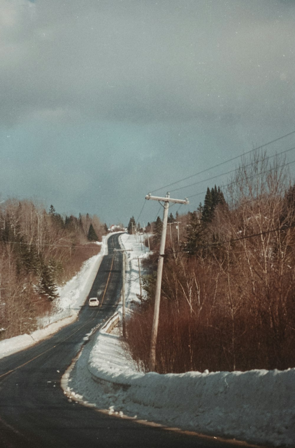 a car driving down a snow covered road