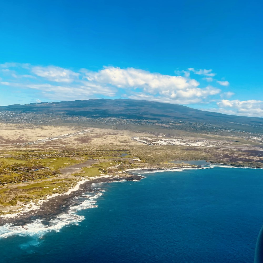 an aerial view of a large body of water with a mountain in the background