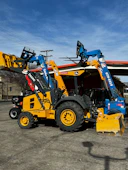 Yellow backhoe loader and blue telehandler