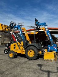 Heavy construction machinery parked neatly inside a secure warehouse.