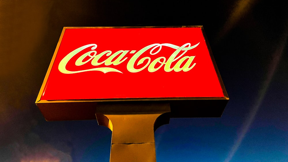 a coca cola sign lit up at night