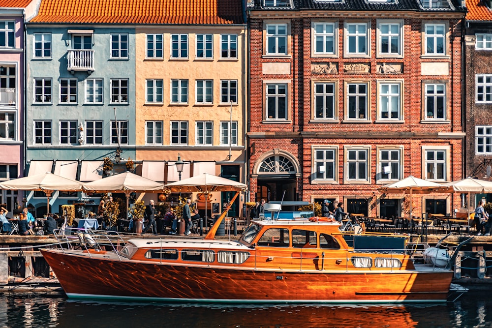 a boat is docked in front of a row of buildings