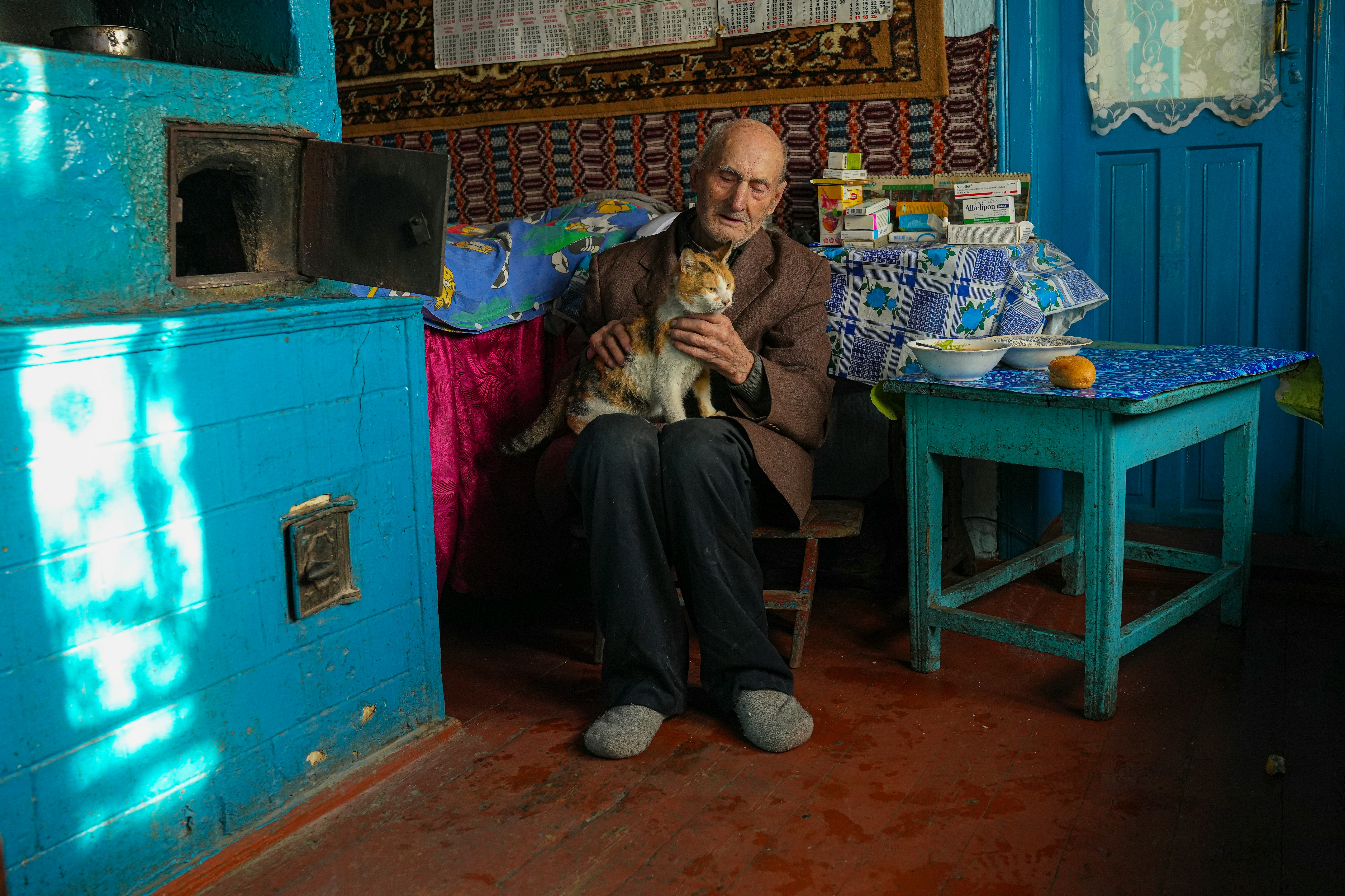a man sitting on a chair holding a cat