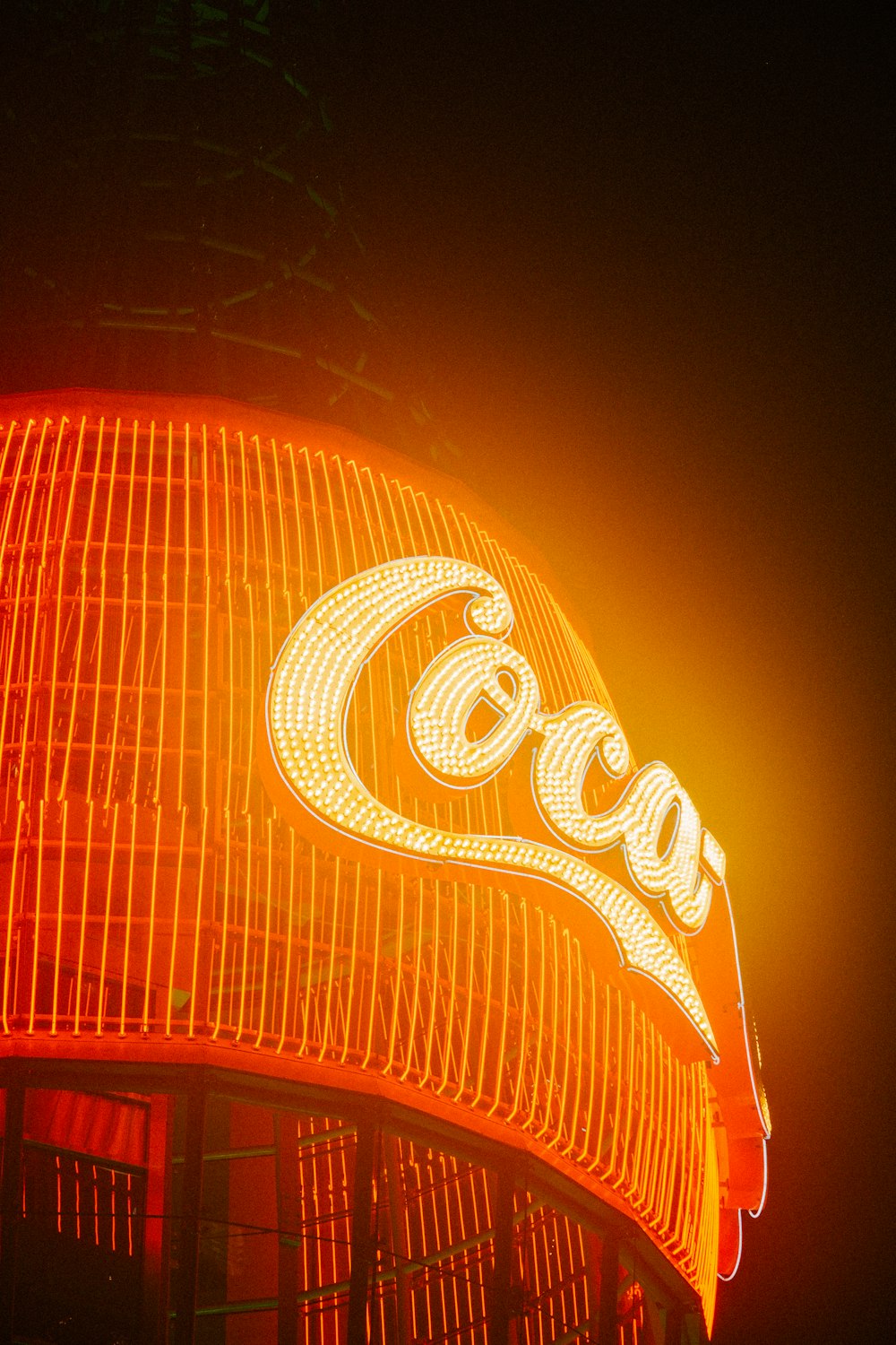 a coca cola sign lit up at night