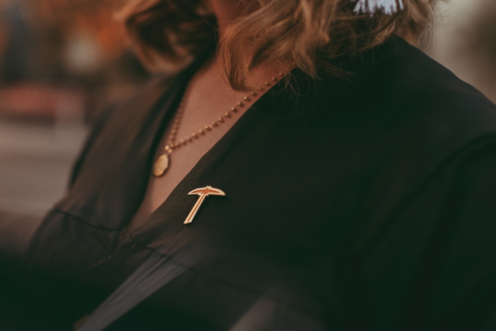 a woman wearing a necklace with a letter t on it
