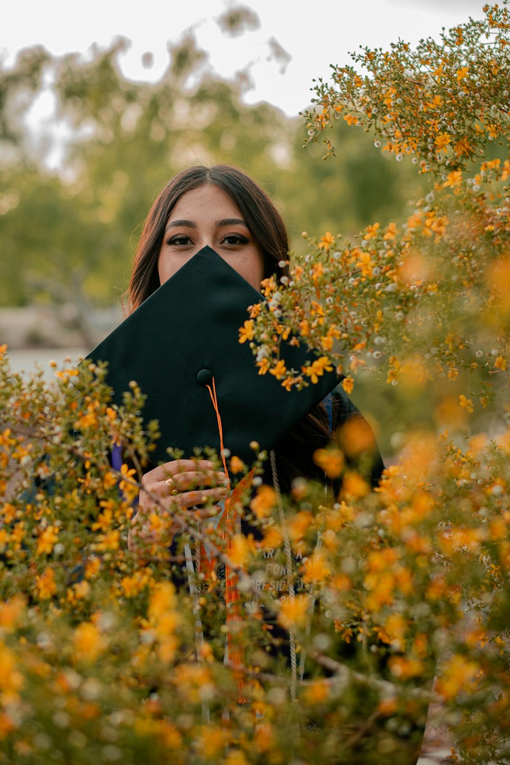 a woman hiding her face in a field of flowers