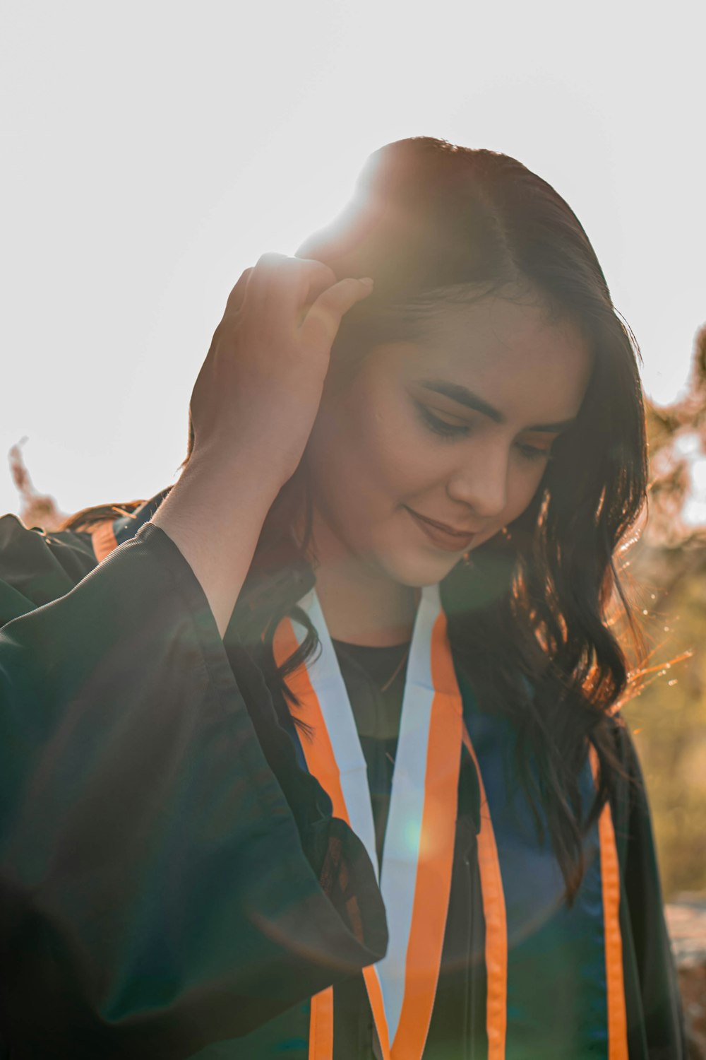 a woman in an orange and black jacket holding a medal