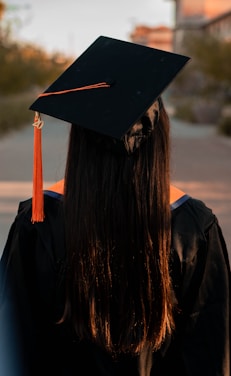 Mujer con birrete y toga de graduación en la página de homologación de títulos.