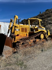 A rugged bulldozer clearing dense brush on a sunny Texas property.
