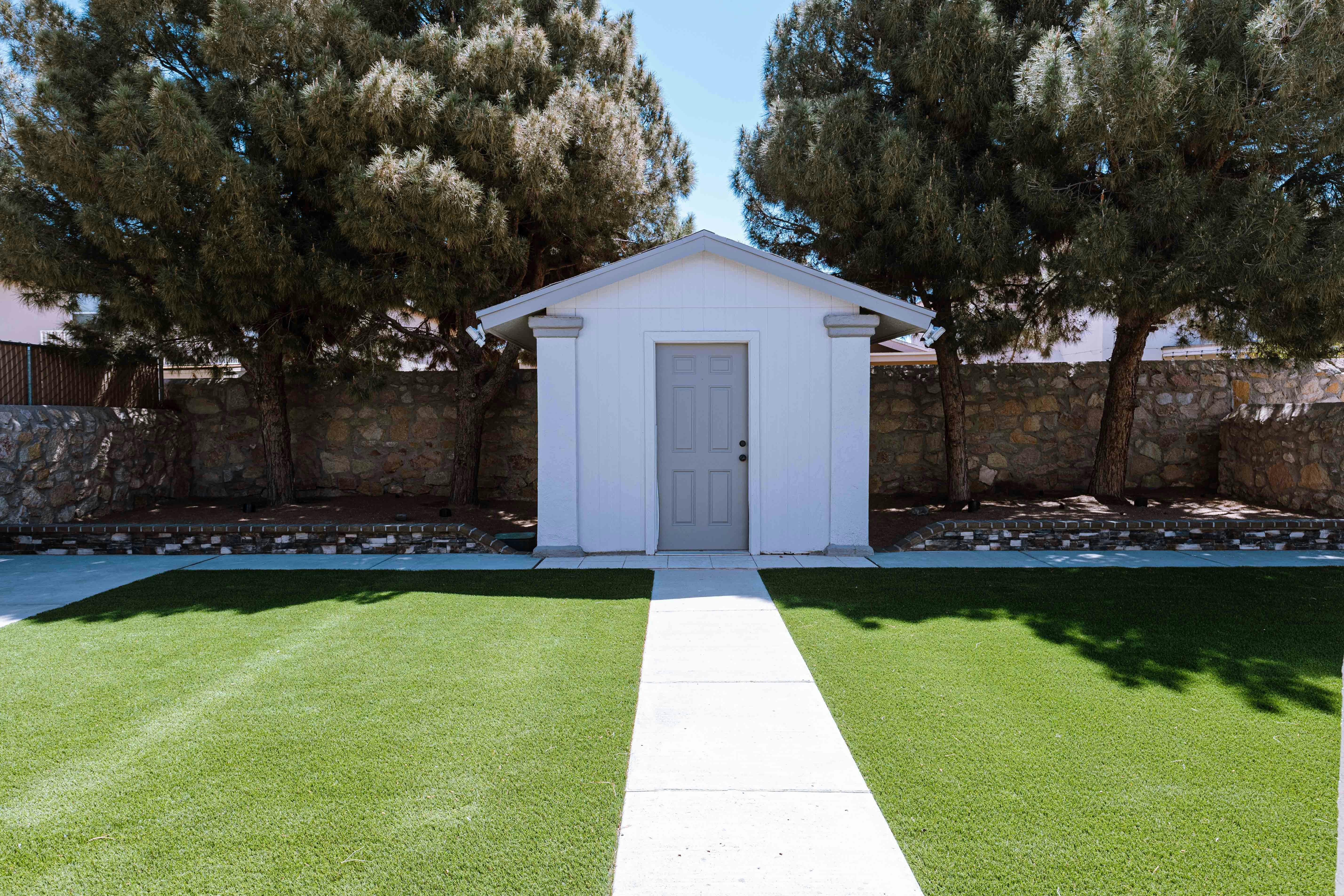 마당 한가운데에 앉아 있는 작은 흰색 창고