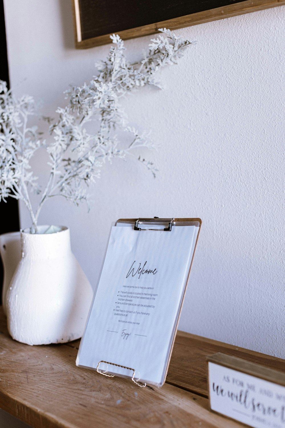 a table with a clipboard and a vase of flowers