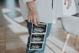A friendly ultrasound technician performing a scan in a bright, welcoming clinic room.