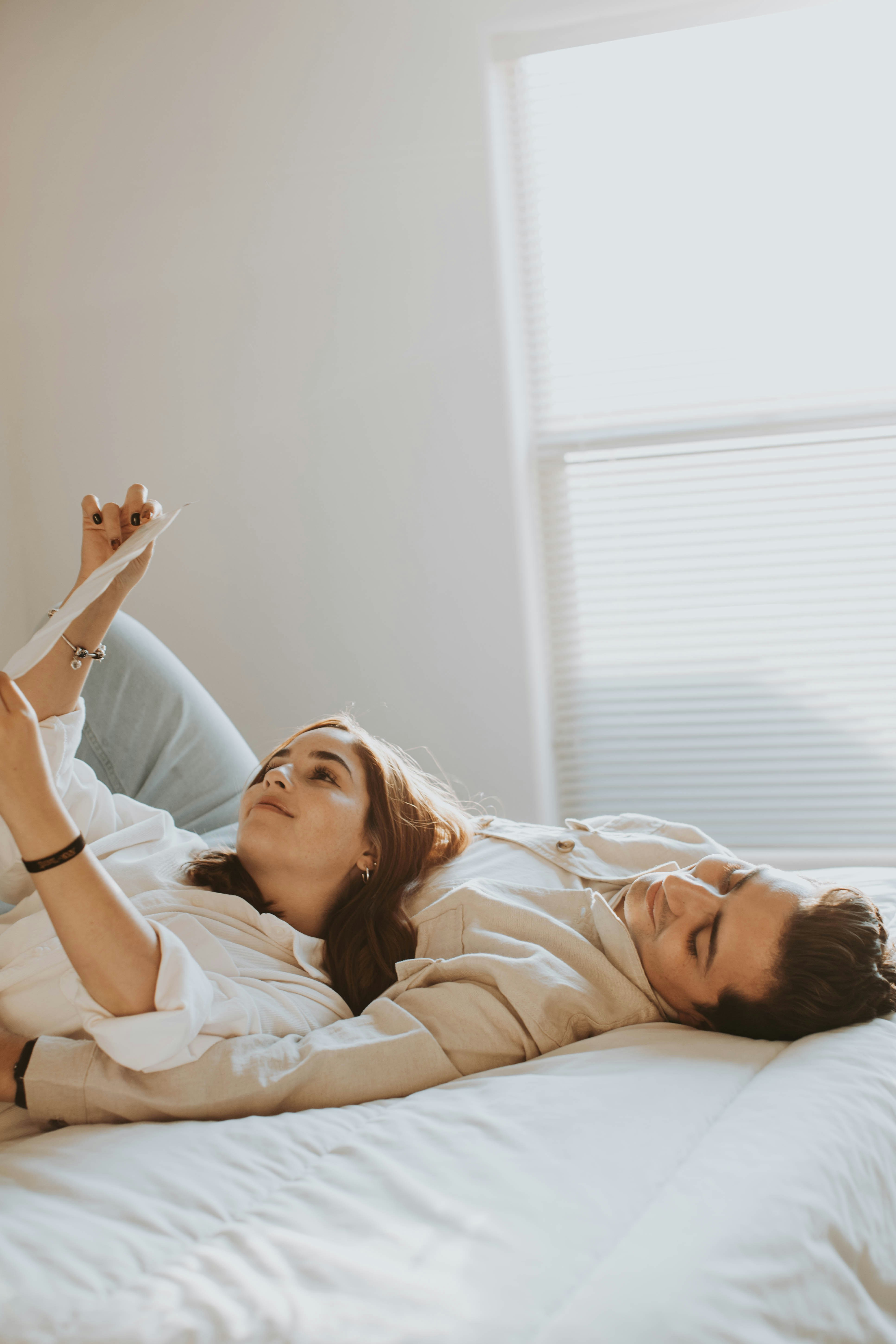 a couple of women laying on top of a bed