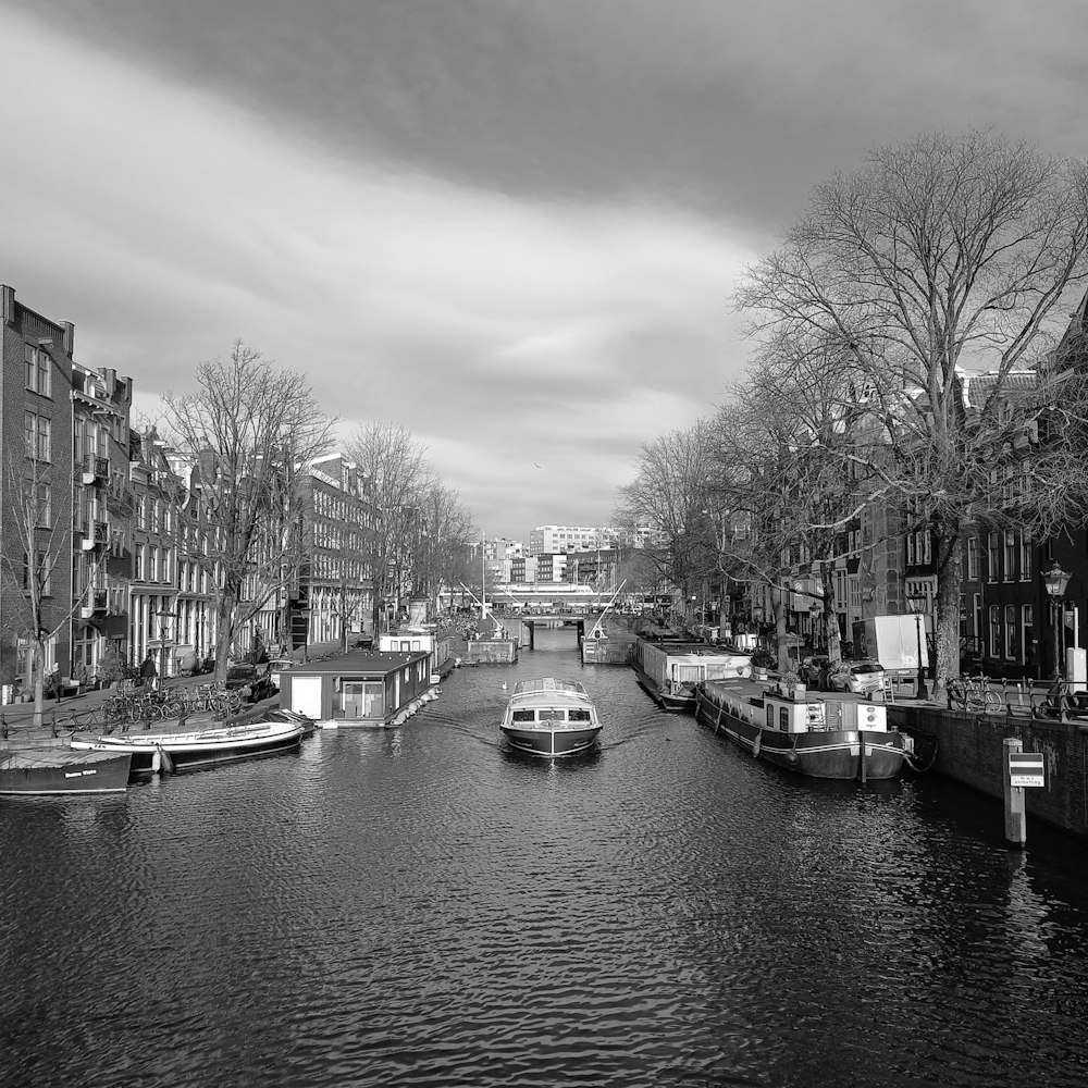 a black and white photo of a canal in a city