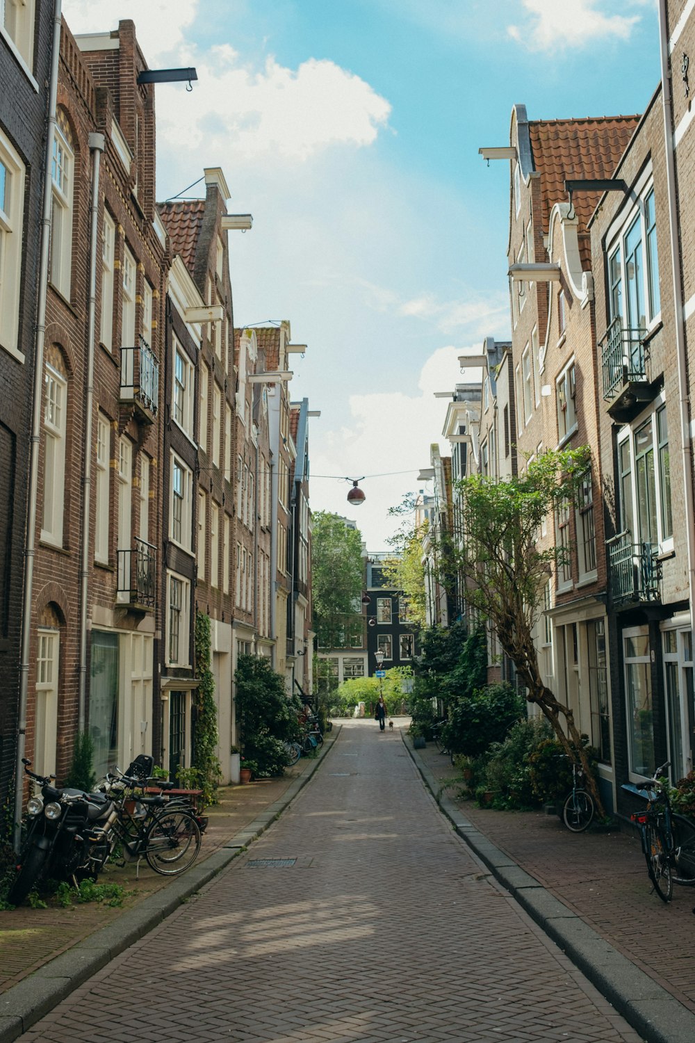 a narrow street lined with brick buildings and bicycles