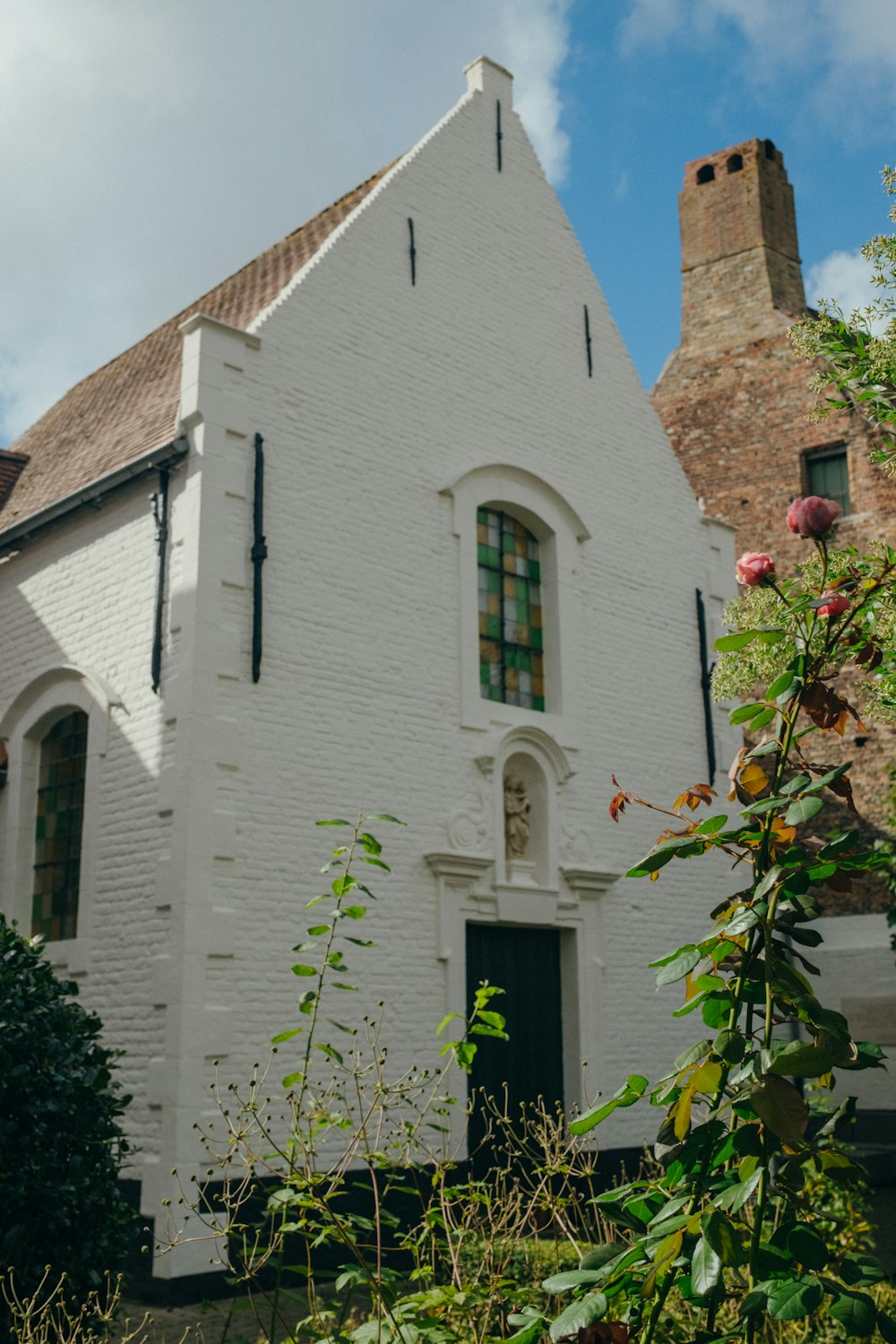 a white building with a rose bush in front of it