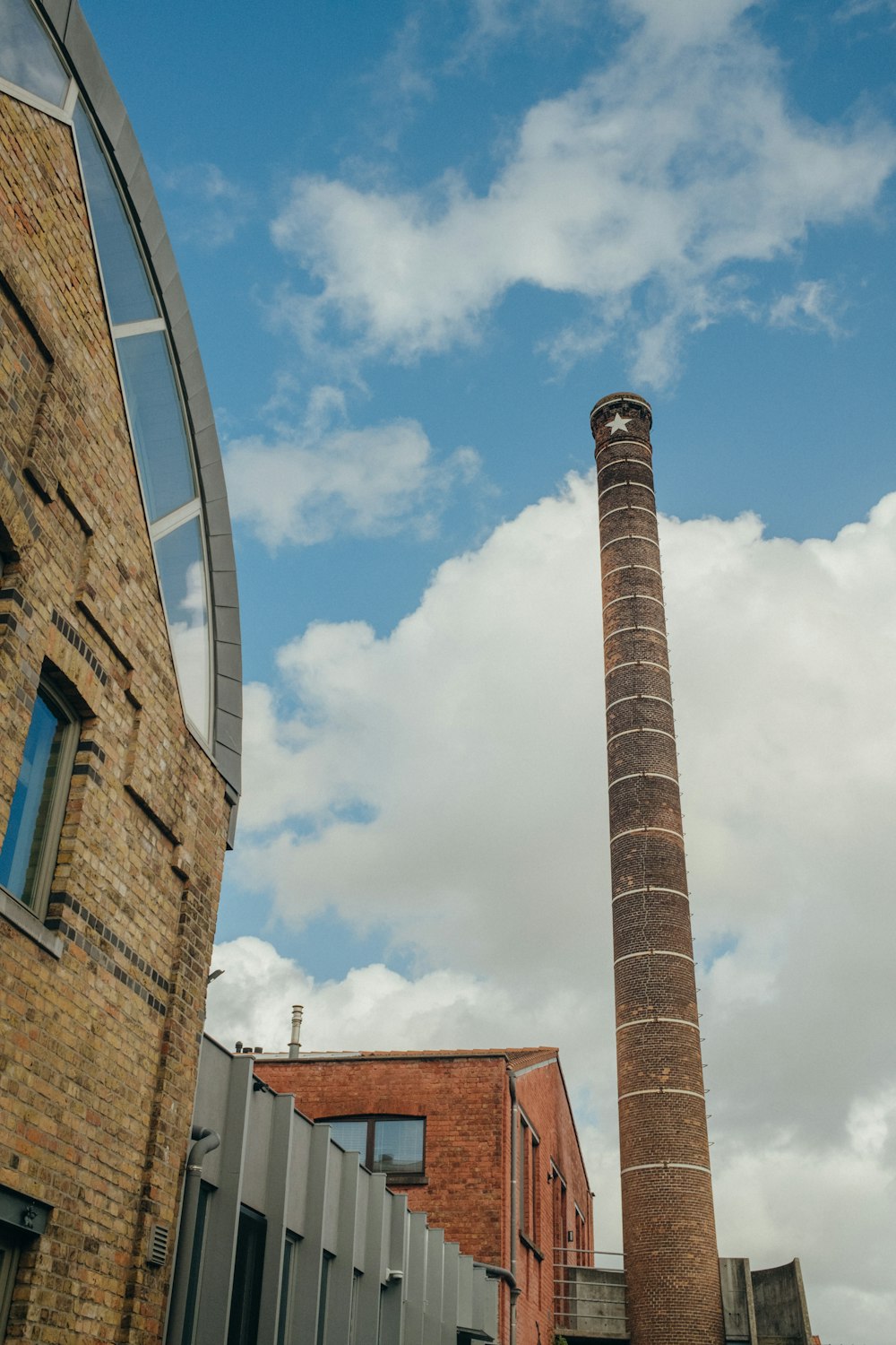 a tall brick chimney next to a brick building