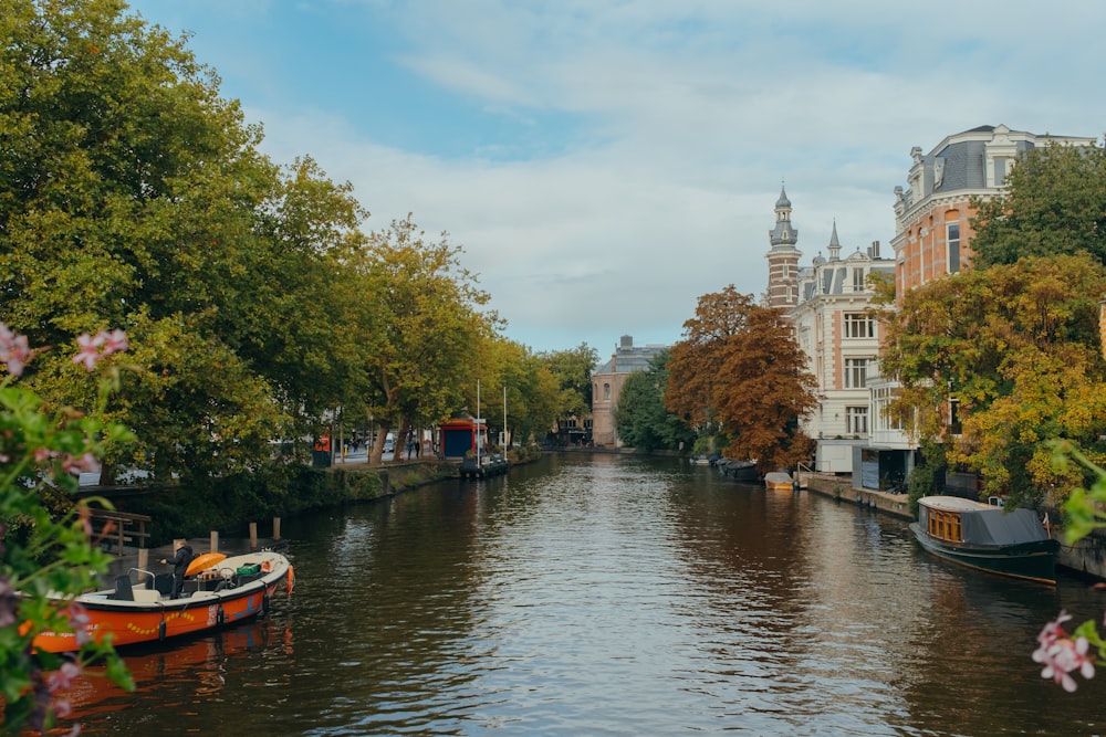 a boat traveling down a river next to tall buildings