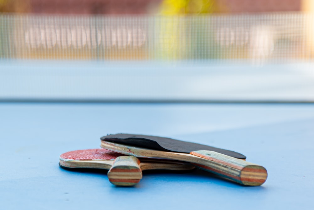 a pair of paddles sitting on top of a blue table